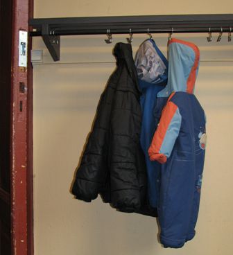 Three coats hanging in a museum cloakroom